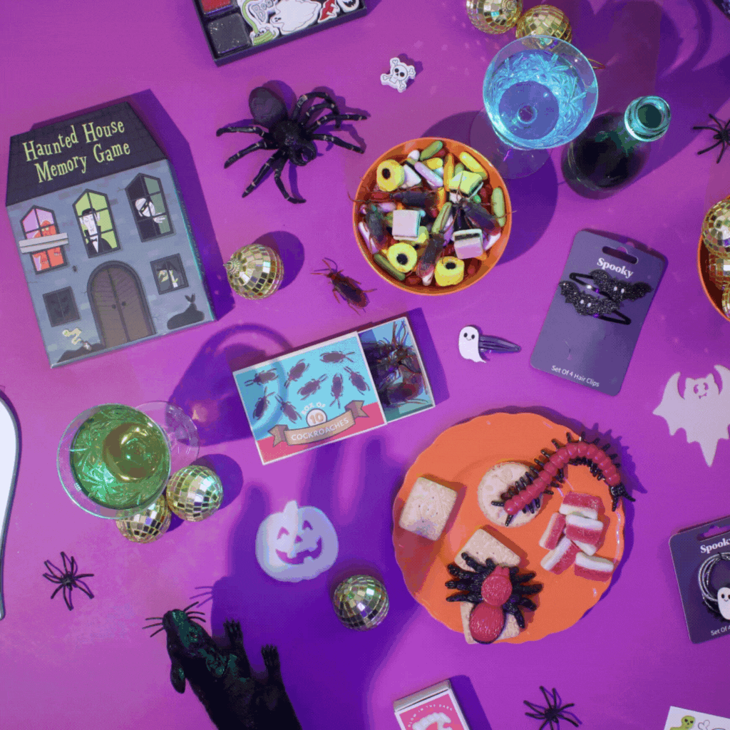 A GIF of a hand with Halloween tattoos reaches for a bowl of sweets