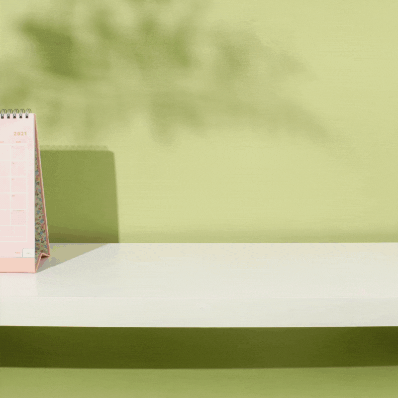 A looping GIF of two tea-themed storage tins sliding across a desk, filled with stationery