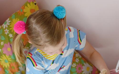 Child wearing pom pom hair bands