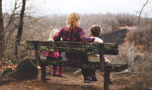 mother sat on the bench with two children