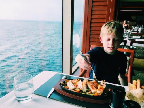 young boy eating on a cruise ship