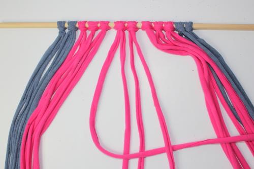 a macrame knot being tied to create a macrame decoration