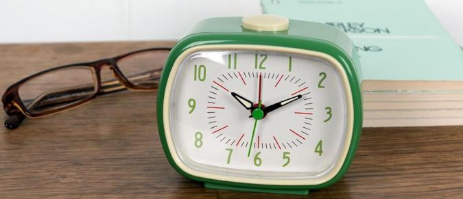 Green retro alarm clock on a bedside table