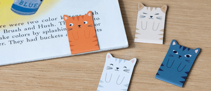 Magnetic cat bookmarks next to a book