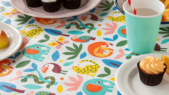 A party table set with cupcakes, colourful plates, cups, and festive decorations—ready for a celebration.