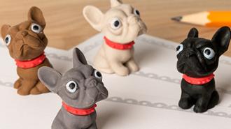Four small erasers shaped like French Bulldogs in brown, white, grey, and black, each wearing a red collar.