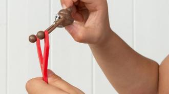 Child's arms about to sling a plastic poo