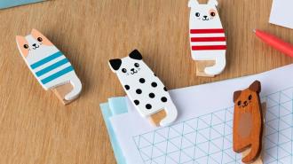 Four wooden pegs on top of notebook on a wooden surface