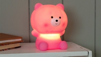 Pink teddy bear night light with light on