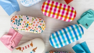 Assorted patterned sunglasses cases with cleaning cloths arranged on a light surface.