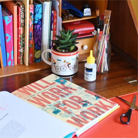 A desk with a bicycle mug with a succulent planted inside