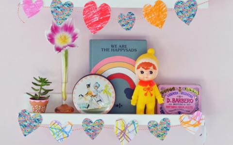 Homemade paper heart garland strung across a shelf