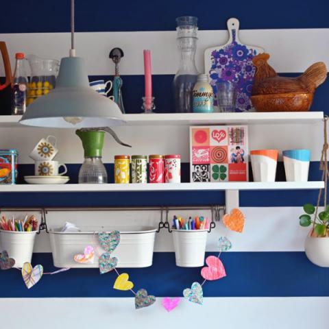 Homemade paper heart garlands strung across shelves in a kitchen