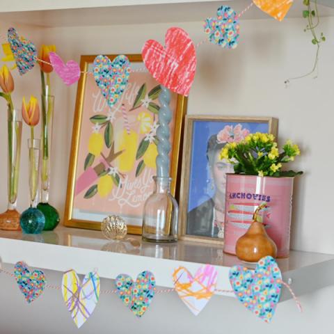 Homemade paper heart garlands strung across shelves