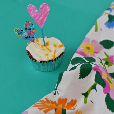 A cupcake with a homemade paper heart topper 