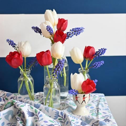 Red, white and blue flowers in little glass jars