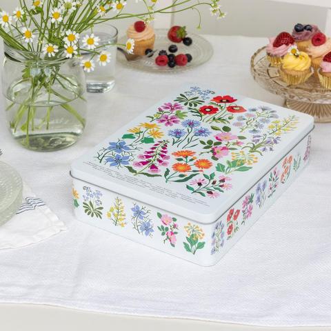 Wild Flowers biscuit tin on a table next to some cupcakes and a vase of flowers