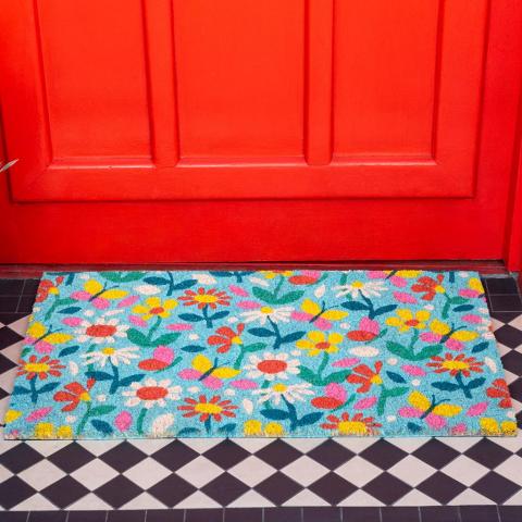 Butterfly Garden doormat in front of a red door