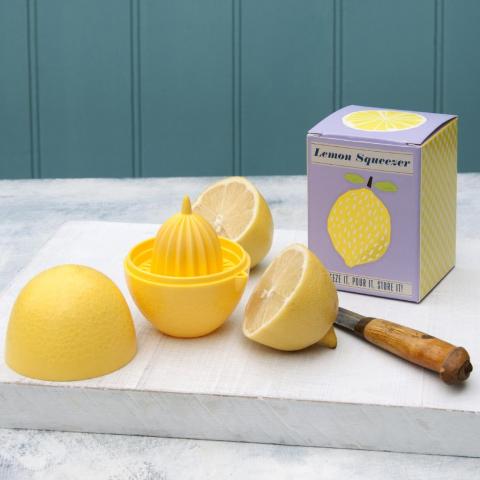 Yellow lemon squeezer with a lemon cut in half