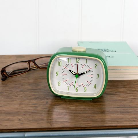 Green retro alarm clock on a bedside table