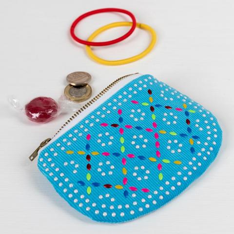 Blue beaded purse next to hairbands and coins