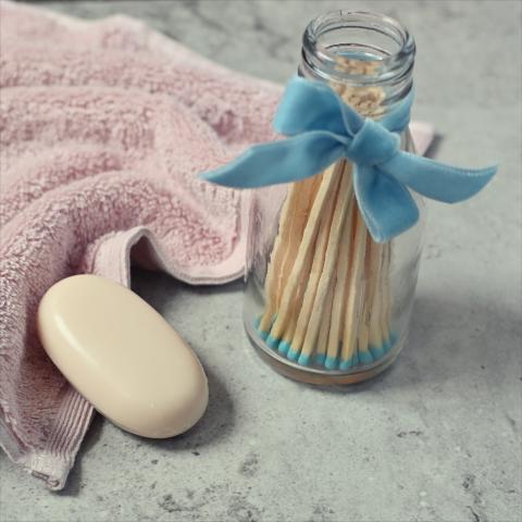 Blue tipped matches in a jar, next to a towel and some soap