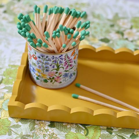 Colourful matches in a floral tin on a yellow tray