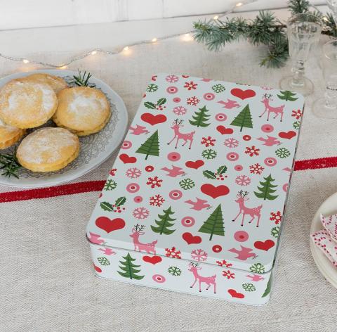 Christmas biscuit tin next to a plate of mince pies