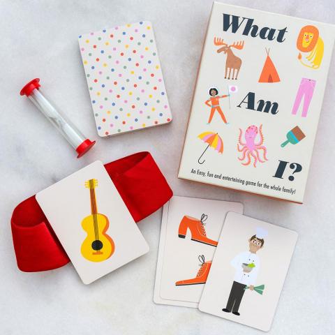 Game pieces from the What Am I? game, including sand timer, headband and cards