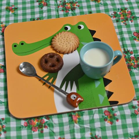Milk and biscuits on a crocodile placemat
