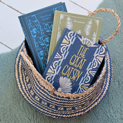 A navy belly basket holds three hardback books