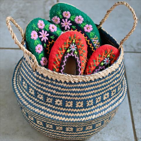 A navy belly basket holds two pairs of colourful slippers
