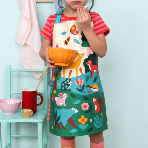 Child in apron holding bowl
