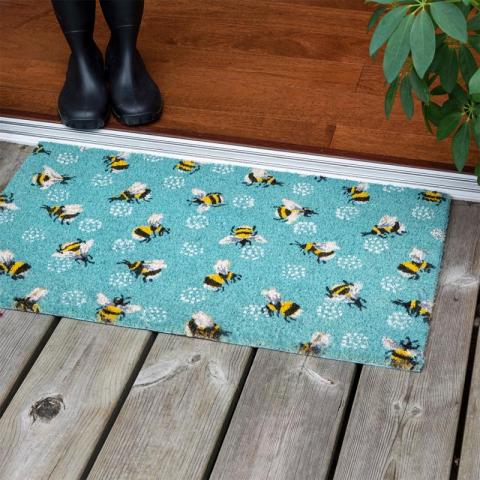 Doormat with bumblebees on wooden floor outside