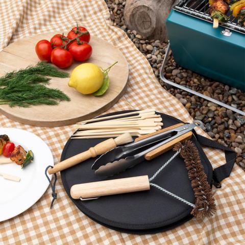 BBQ tools with food on outside blanket
