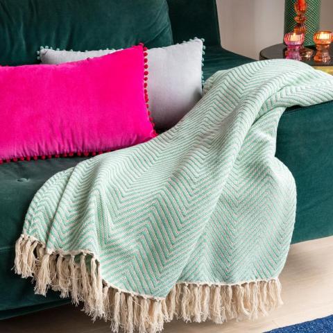 Aqua throw with pink and grey cushion on sofa