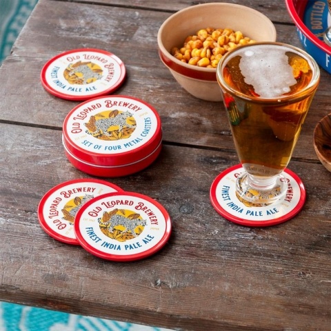 Several coasters with beer glass and snacks on wooden table