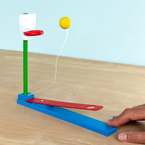 wooden tabletop basketball game with a lever launching a yellow ball toward a hoop
