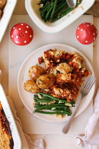 Roast potatoes on plate with green beens next to mushroom shakers