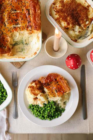 Peas and pie in serving dishes and plate on dining table