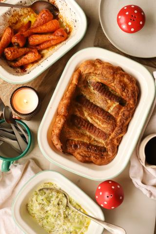 Baked dish, leeks and carrots all in white serving dishes