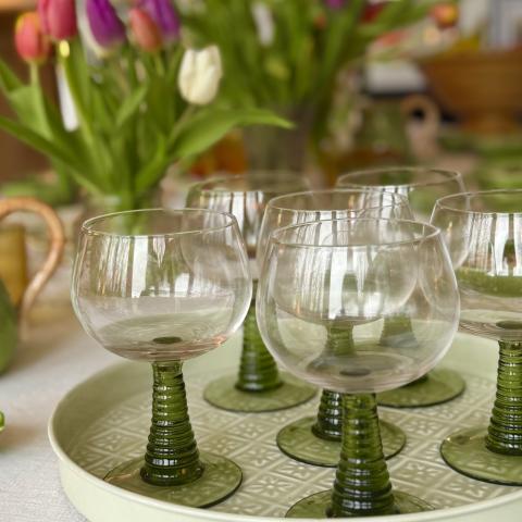 Green glasses with flowers in background