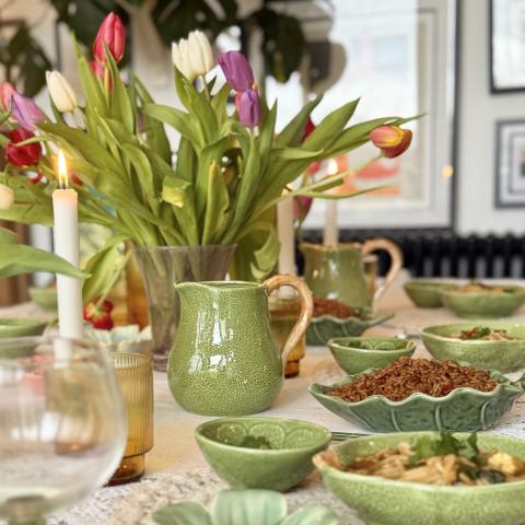 Green tableware and spring tulips on table