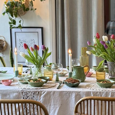 Green decor on white tablecloth on dining table