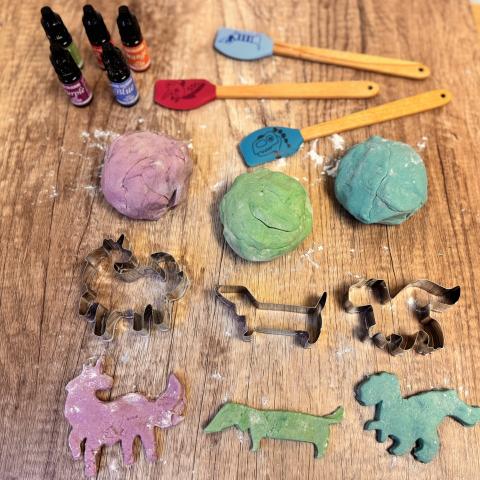 Different coloured play dough with cutter shapes and spatulas