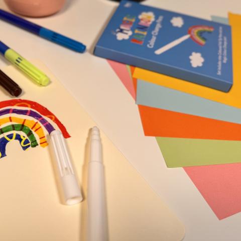 Pens, rainbow drawing and cardboard paper