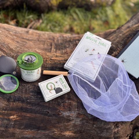 Range of nature trail products for kids on log outdoors