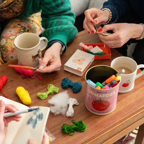 women sat around a table making crafts and drawing