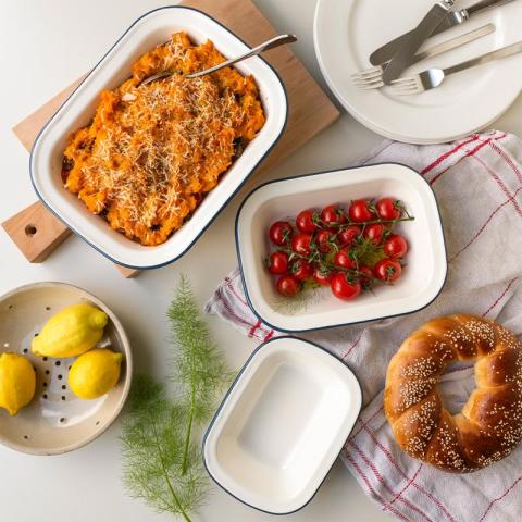 Pasta, tomatoes and bread in white tableware