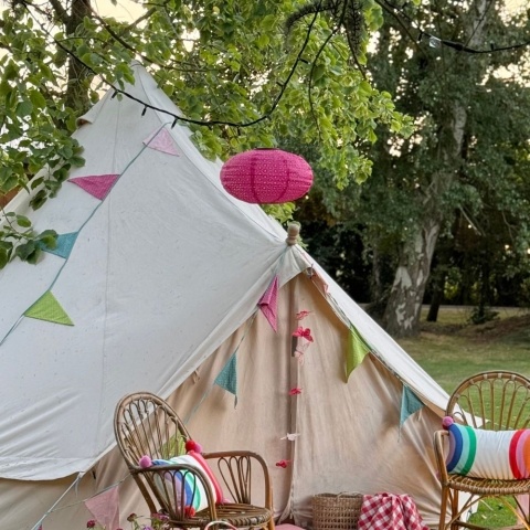 A large white tent is hung with colourful spotty bunting